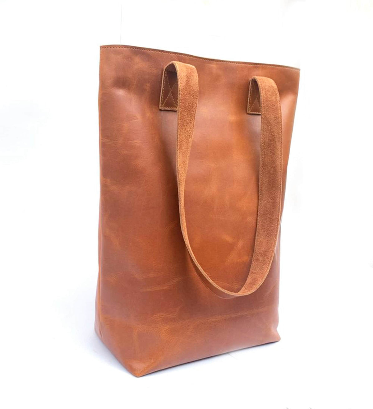 May include: A brown leather tote bag with two long straps. The bag is made of a soft, supple leather and has a spacious interior.