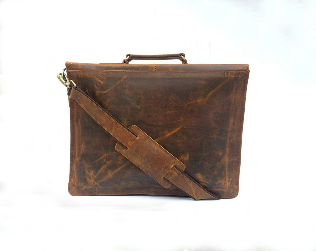 May include: A brown leather briefcase with a long adjustable shoulder strap. The bag has a top handle and a distressed leather finish.