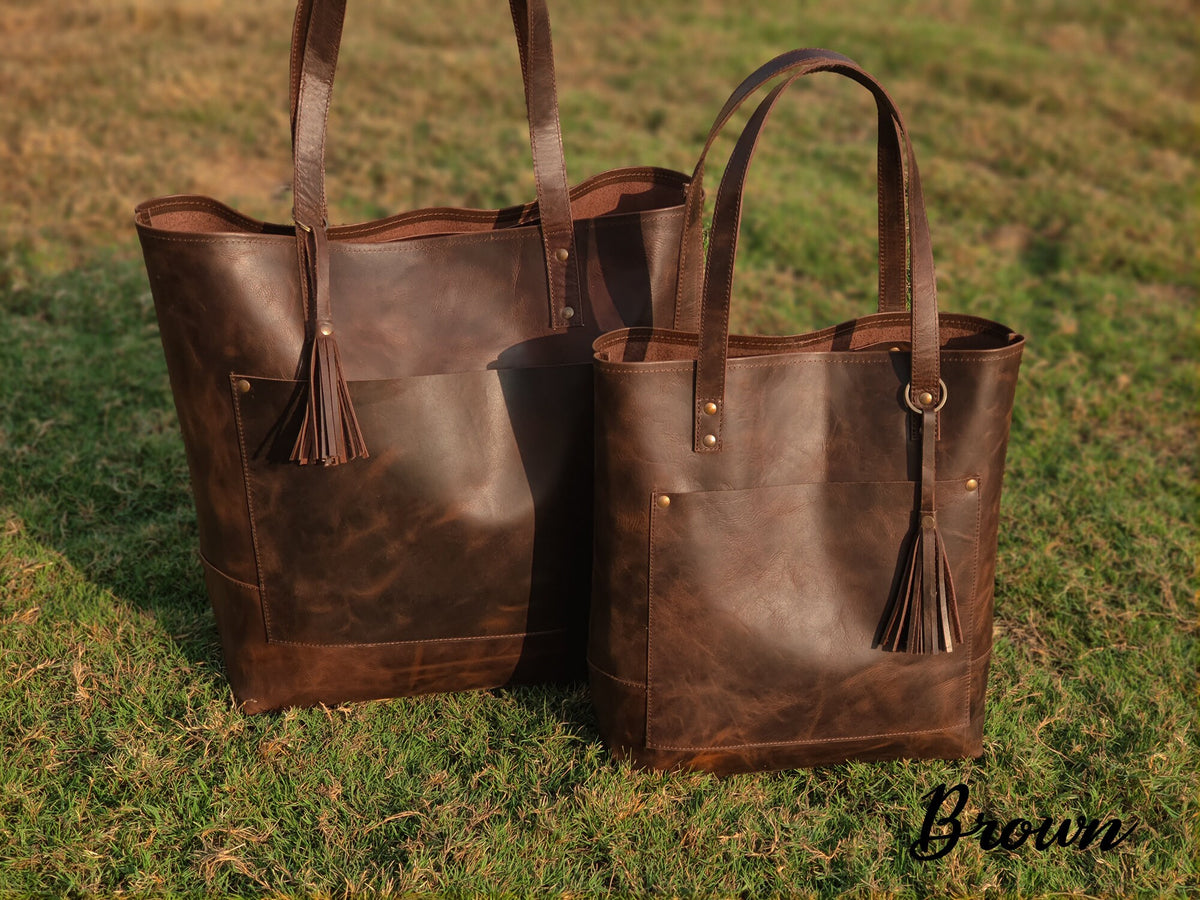 May include: Two brown leather tote bags with a tassel detail. The larger bag is in the background and the smaller bag is in the foreground. The word "Brown" is written in cursive at the bottom of the image.