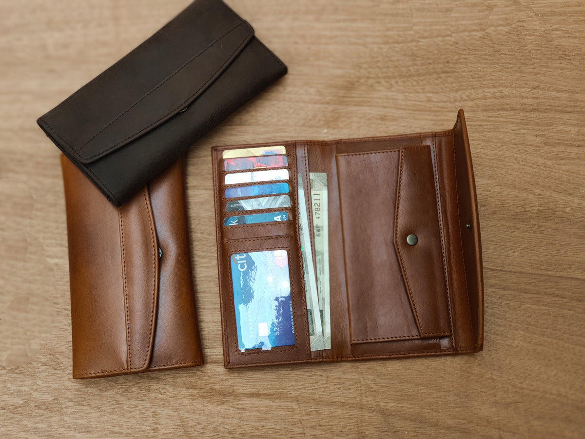 May include: Two leather wallets, one brown and one black, are open and laid out on a wooden surface. The brown wallet has multiple card slots and a billfold, while the black wallet has a more simple design.