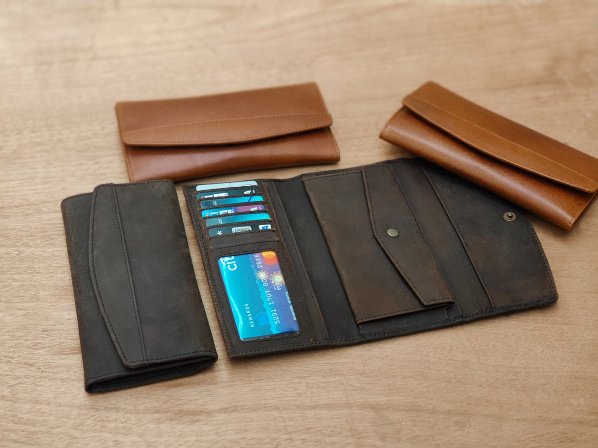 May include: Three leather wallets, one brown and two black, with one open to show multiple credit cards and a blue card with the text "Citi" on it.