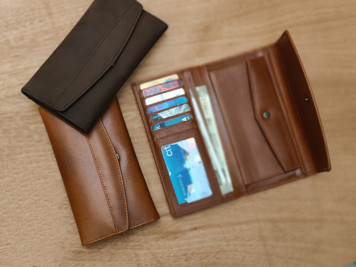 May include: Two leather wallets, one brown and one black, are shown open and closed. The brown wallet has multiple card slots and a billfold. The black wallet is closed.