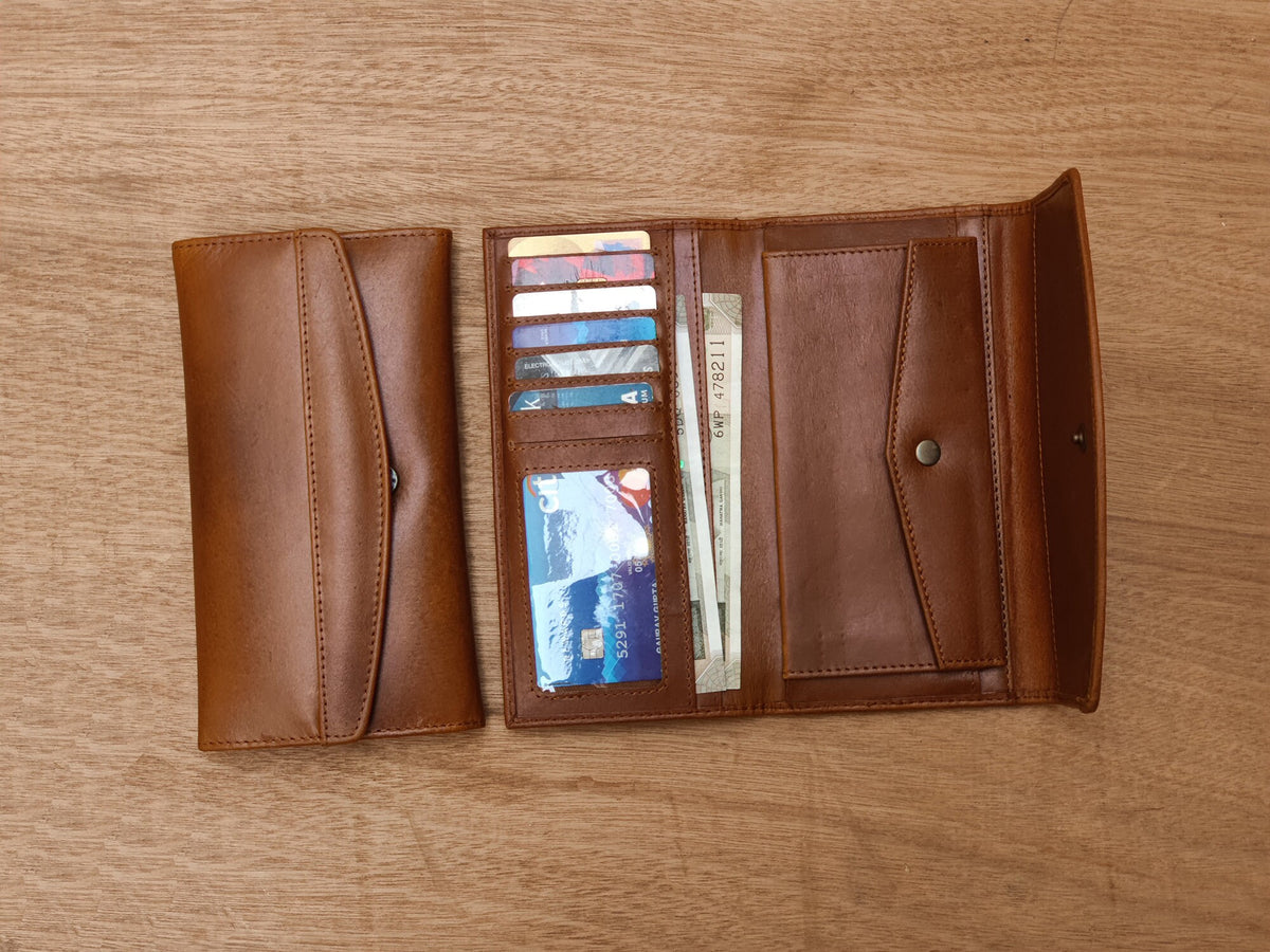 May include: A brown leather wallet with multiple card slots and a billfold. The wallet is open and has several cards and bills inside.