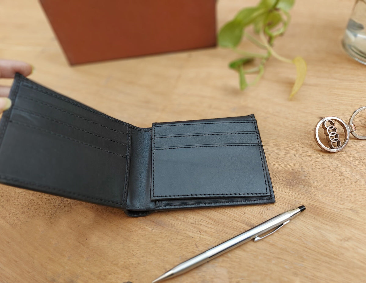 May include: A black leather wallet with multiple card slots and a billfold. The wallet is open and empty.