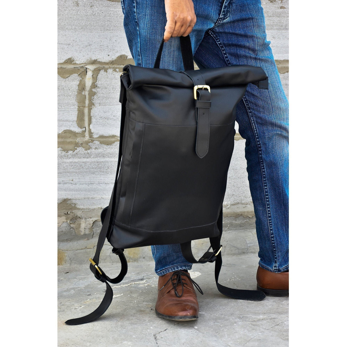 May include: A black leather roll-top backpack with a gold buckle and adjustable straps.