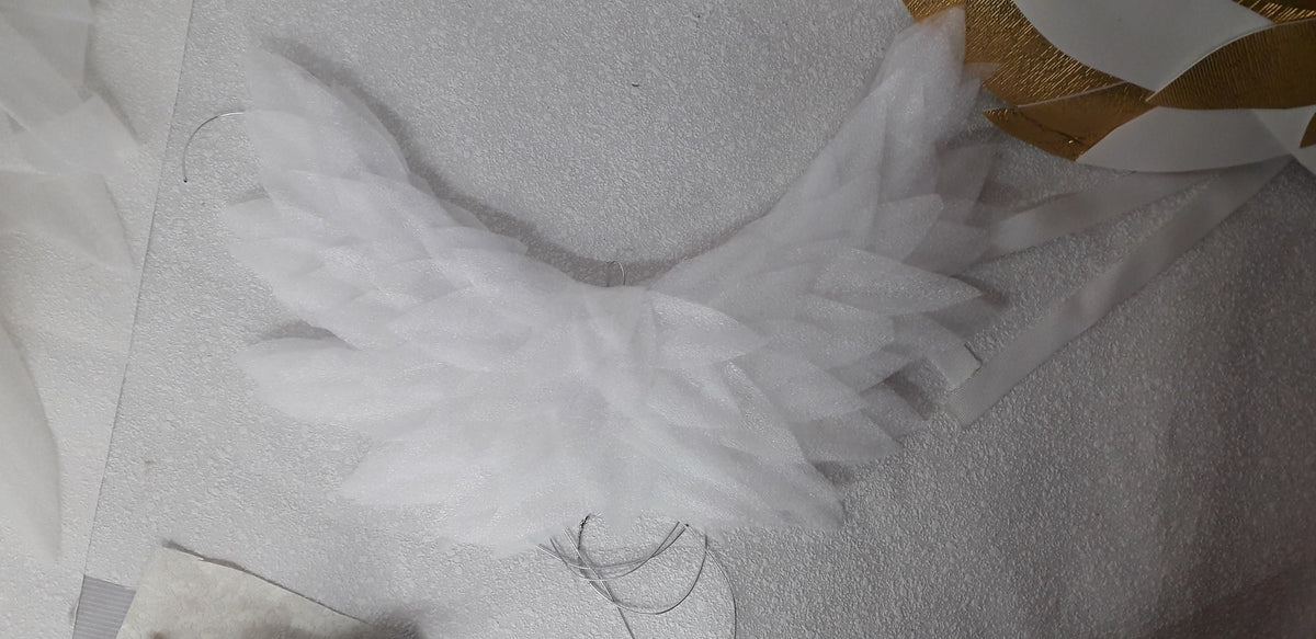 May include: White tulle wings with a layered, feathery design. The wings are attached to a wire frame.