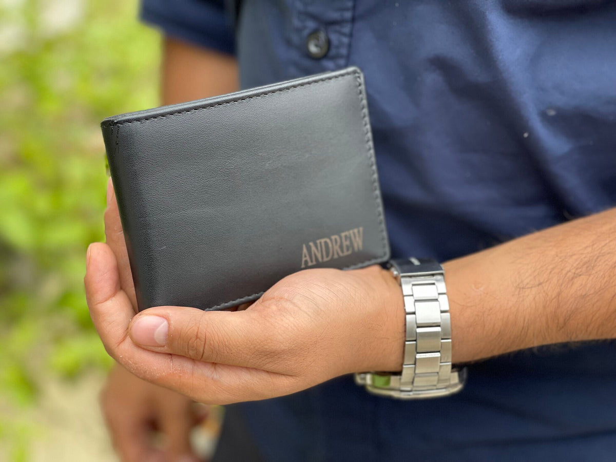 May include: A black leather wallet with the name "ANDREW" engraved on the front.