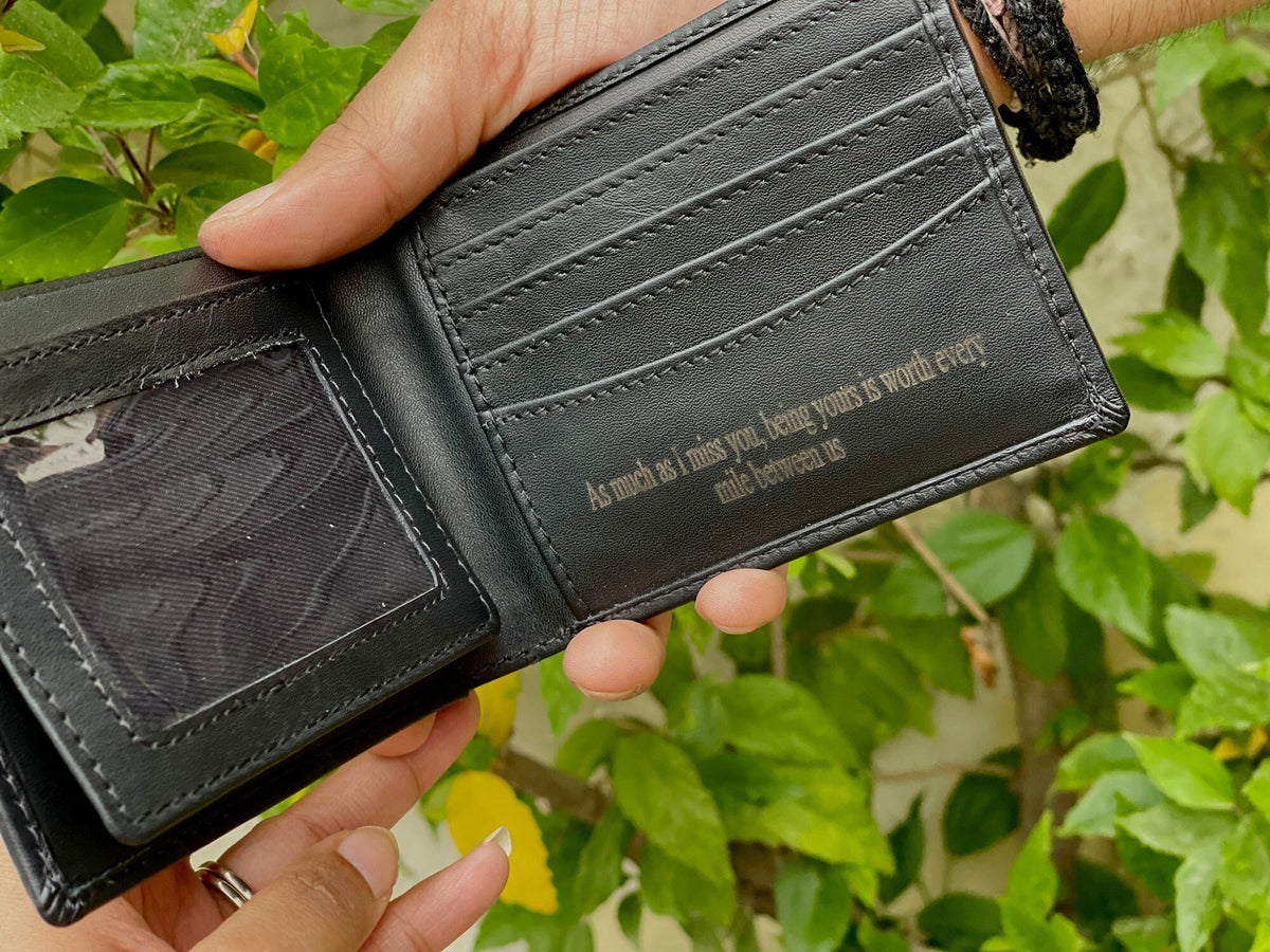 May include: A black leather wallet with a personalized inscription that reads "As much as I miss you, being yours is worth every mile between us".