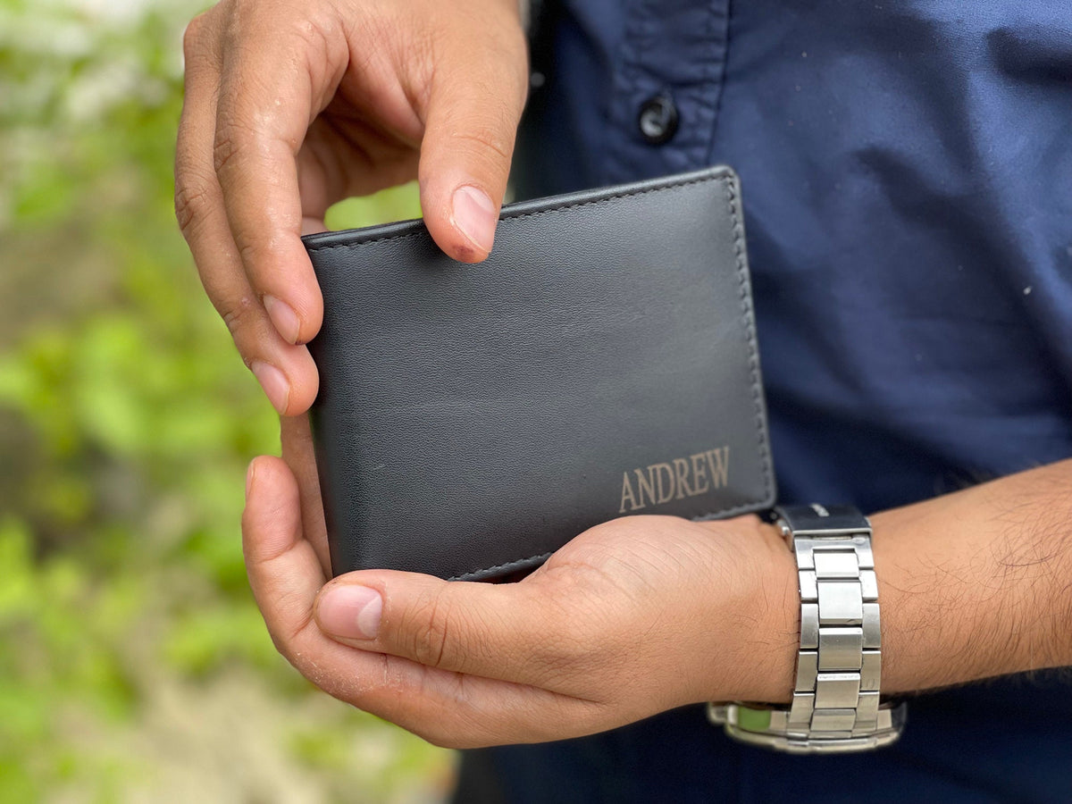 May include: A black leather wallet with the name "ANDREW" embossed in gold lettering.
