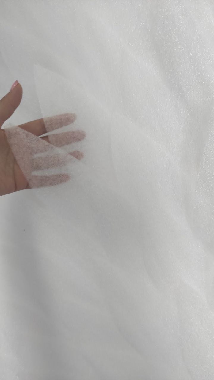 May include: White tulle fabric with a soft, delicate texture. The fabric is sheer and lightweight, making it ideal for crafting and sewing projects.