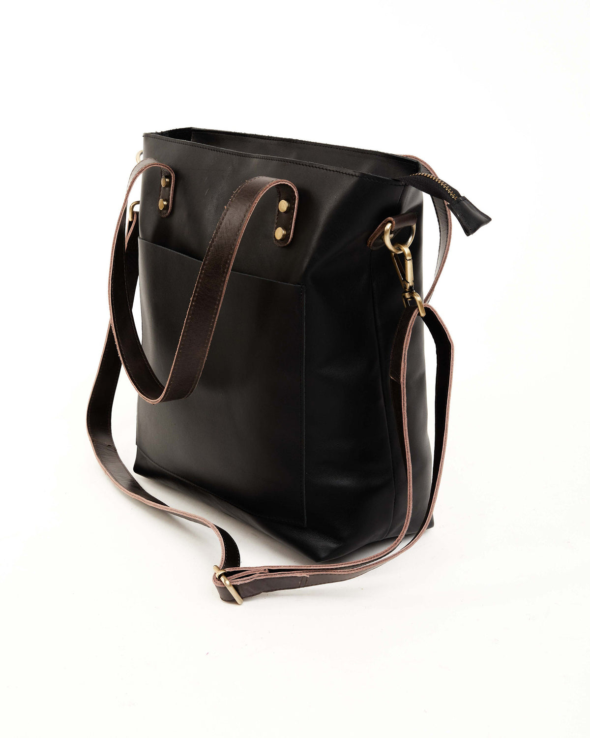 May include: A black leather tote bag with a brown leather strap and a zipper closure. The bag has a front pocket and a top handle.