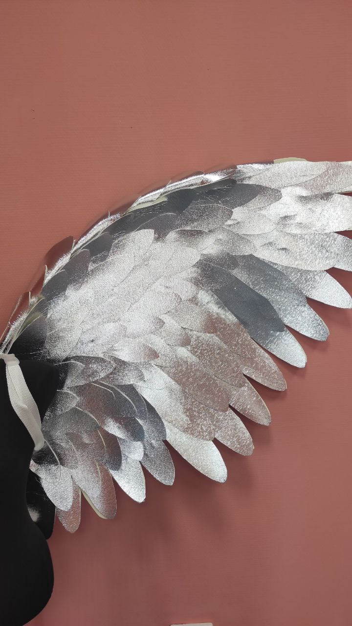 May include: Silver angel wings with a black base. The wings are made of multiple layers of fabric and have a feathery texture.