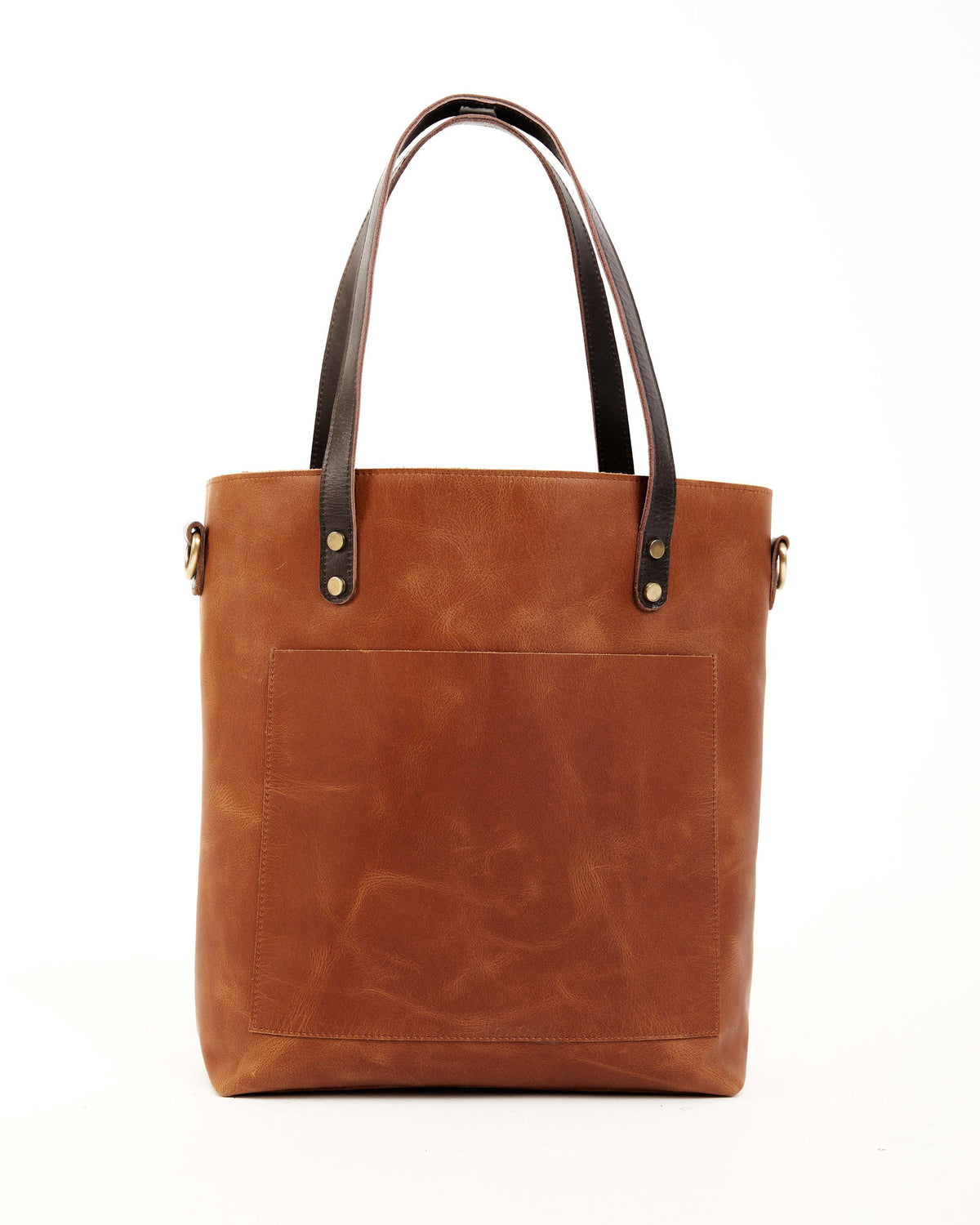 May include: A brown leather tote bag with a front pocket and dark brown leather handles. The bag has gold-colored rivets.