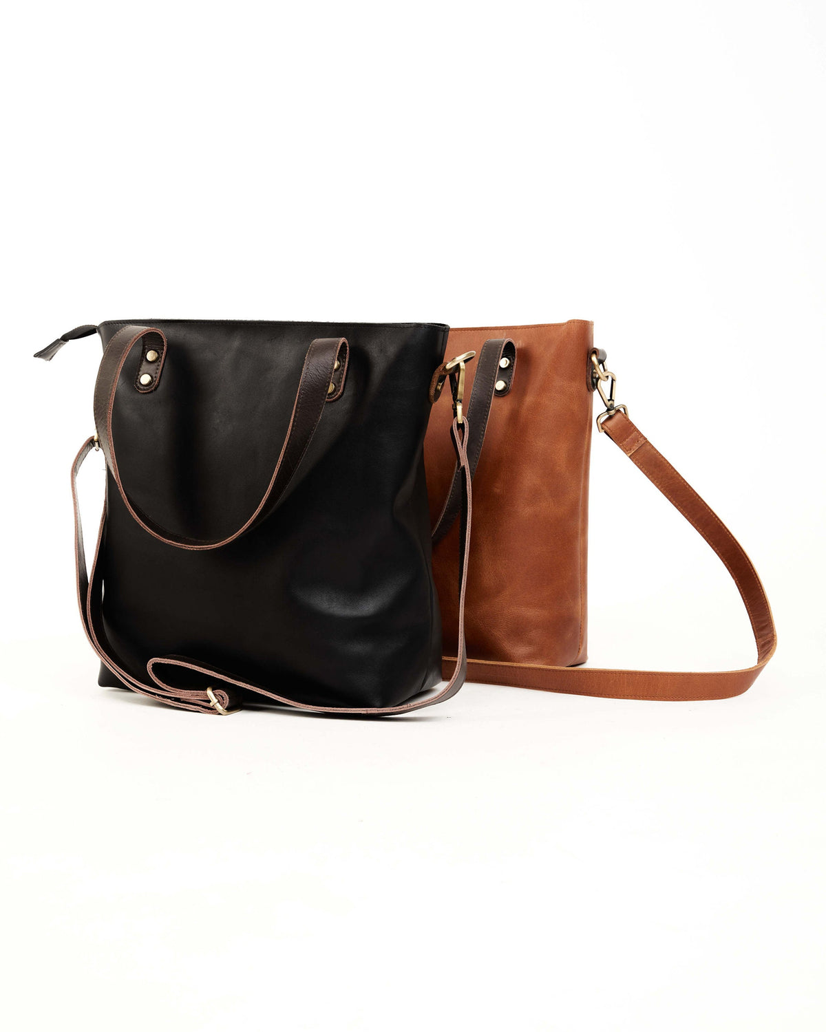 May include: Two leather tote bags, one black and one brown, with adjustable straps. Both bags have a zipper closure and a top handle.
