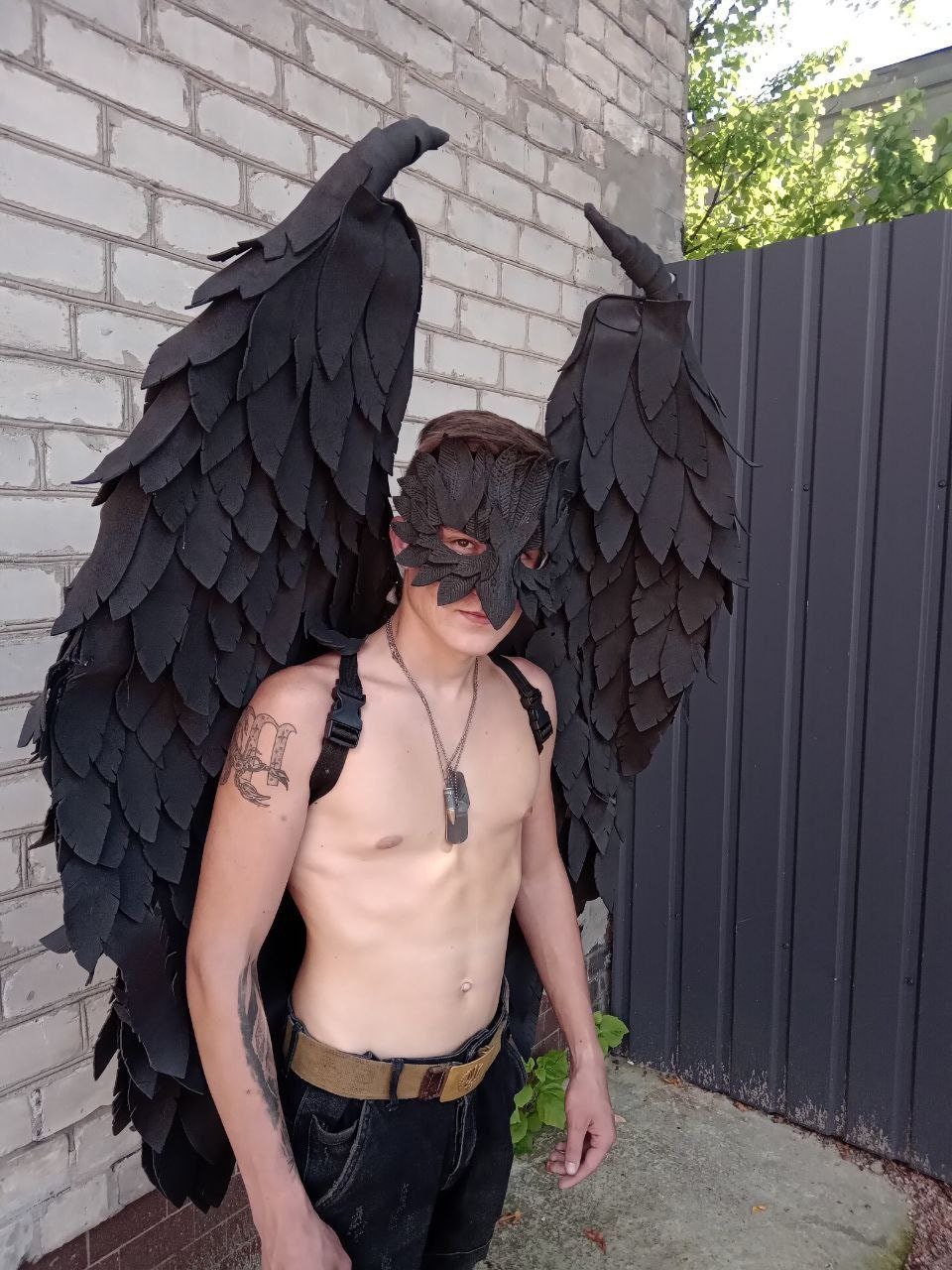 May include: Black costume wings with a matching mask. The wings are large and detailed, with a layered feather design. The mask covers the eyes and nose. The costume is suitable for cosplay or themed events.