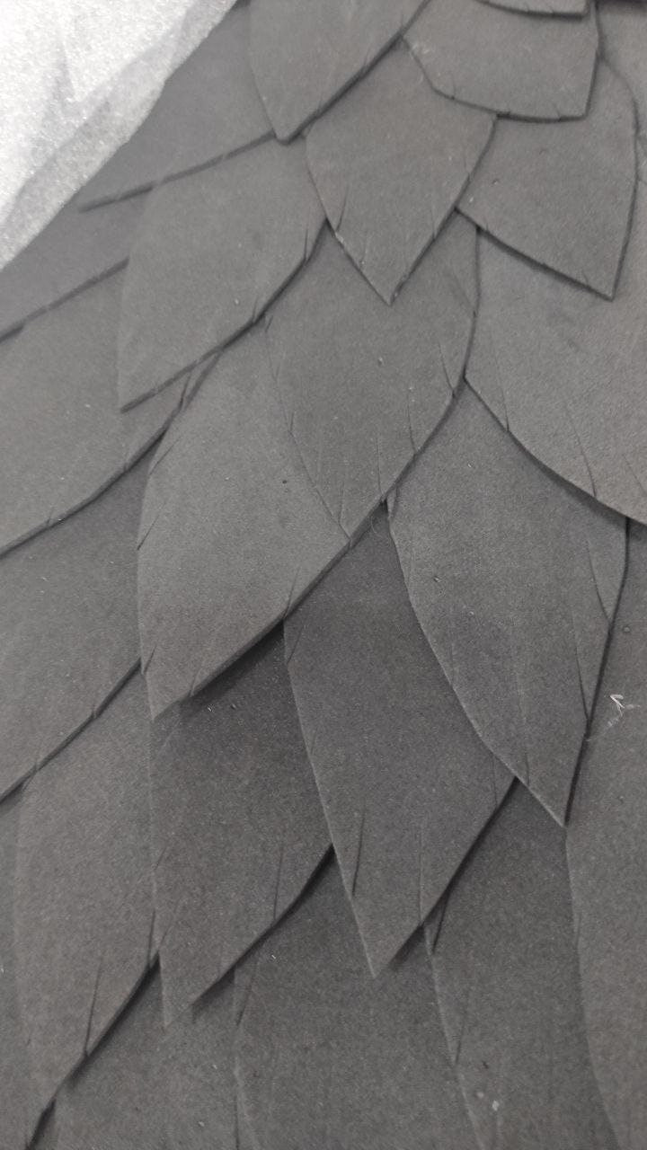 May include: Close-up of a black foam material with a textured surface that resembles scales.