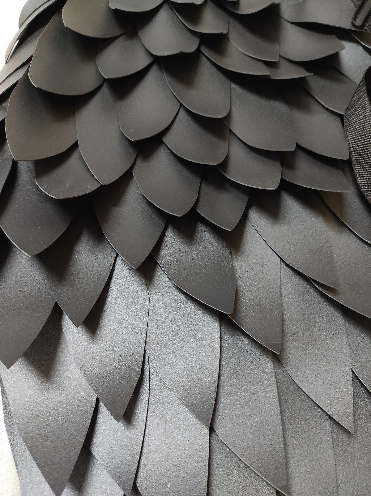 May include: Black leather scales arranged in a pattern, resembling a dragon's back.