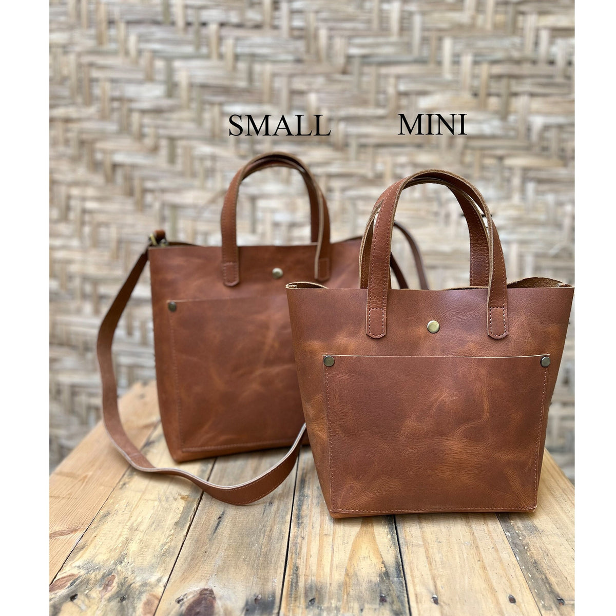 May include: Two brown leather tote bags, one labeled "SMALL" and the other labeled "MINI". Both bags have a front pocket and a top handle.