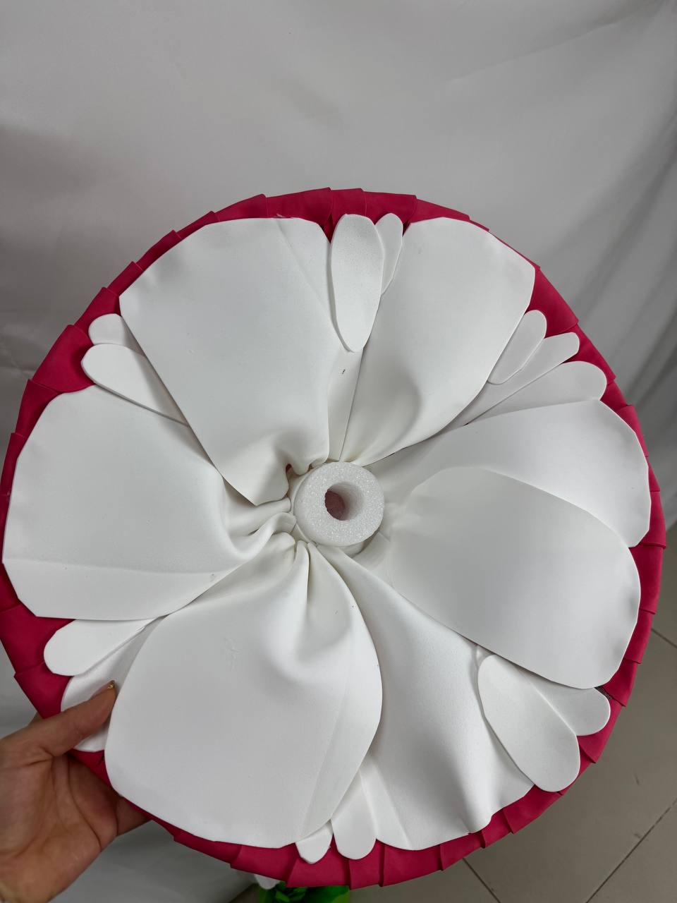 May include: A large, white, fabric flower with a pink fabric base. The flower has multiple petals and a center hole.