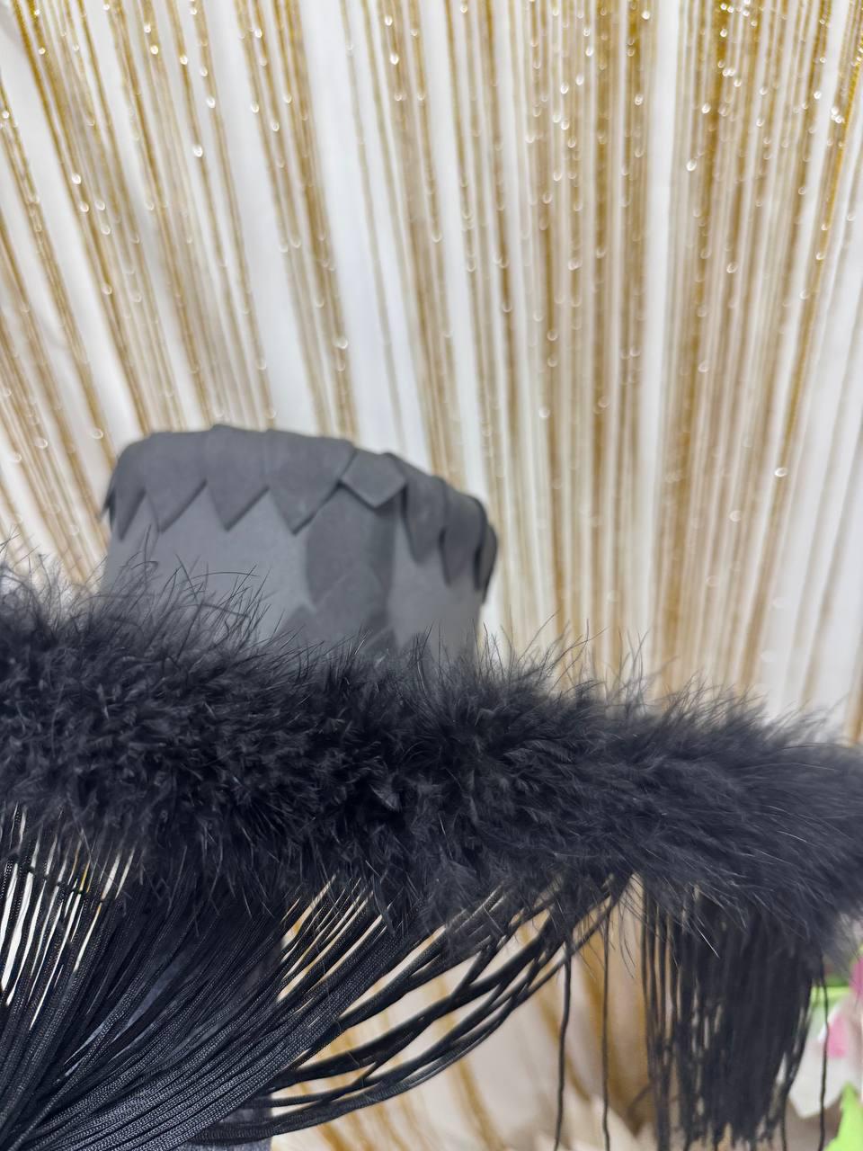 May include: Black feather trim with a fringe detail. The trim is made of soft, fluffy feathers and has a long, flowing fringe.