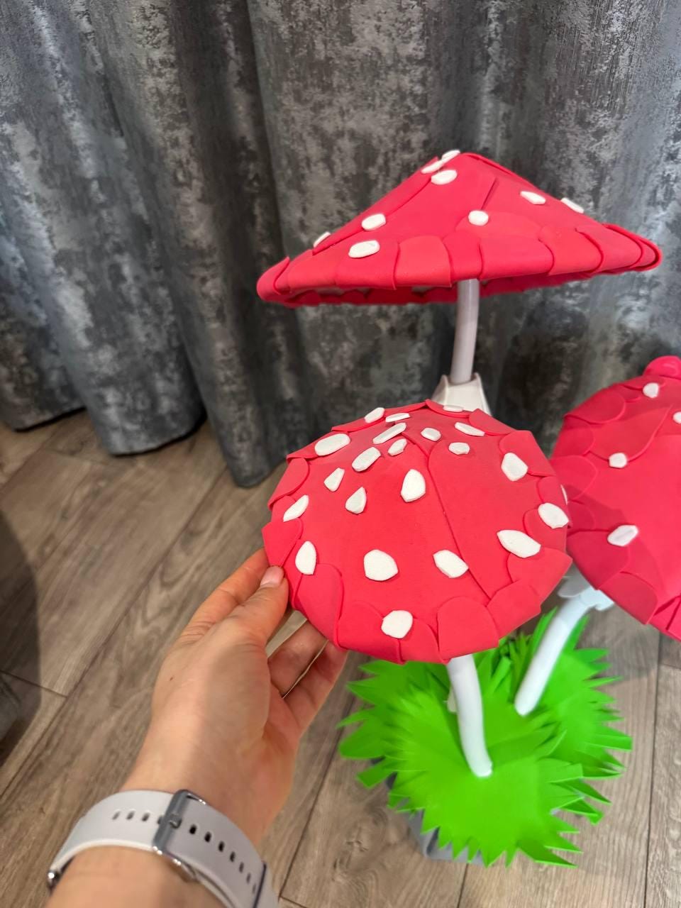 May include: Two large red and white foam mushrooms with white spots on the top. The mushrooms are on a green foam base.