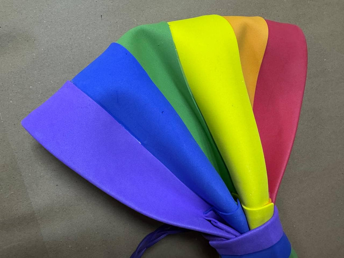 May include: A colorful rainbow-themed accessory, possibly a headband or hair accessory. The item features a spectrum of colors, including purple, blue, green, yellow, orange, and red. The item is tied together with a purple band.