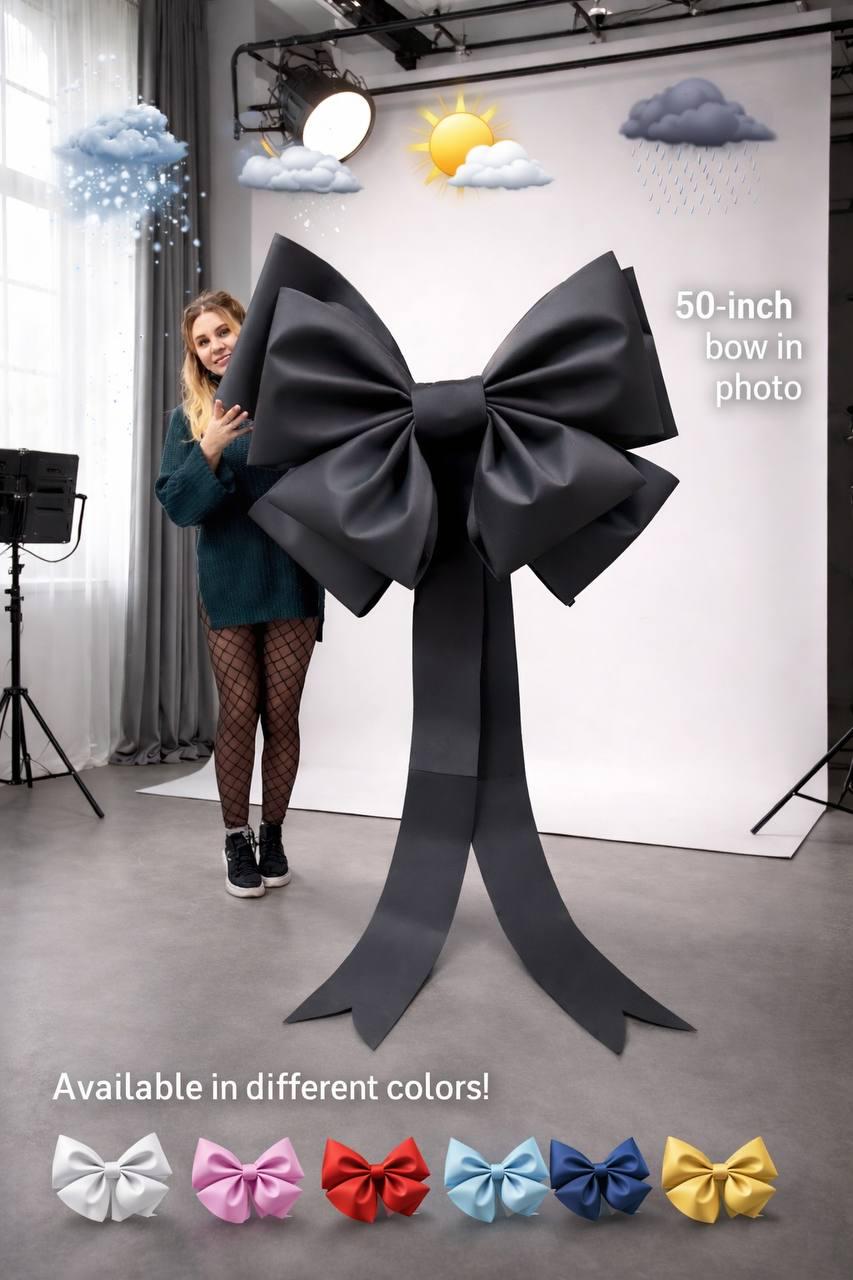 May include: A large, black bow, approximately 50 inches in height, with long, flowing tails. The image includes text that says "50-inch bow in photo" and "Available in different colors!" with examples of bows in various colors.