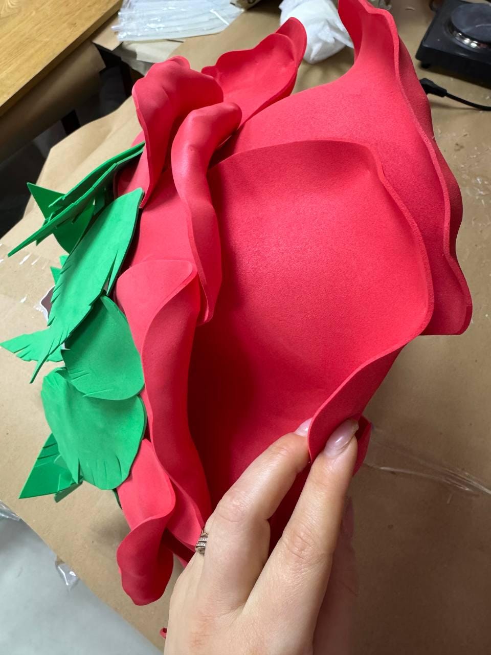 May include: A large, vibrant red rose made of foam, with green leaves attached. The petals are layered and textured, creating a realistic appearance. This craft item is ideal for decorative purposes.