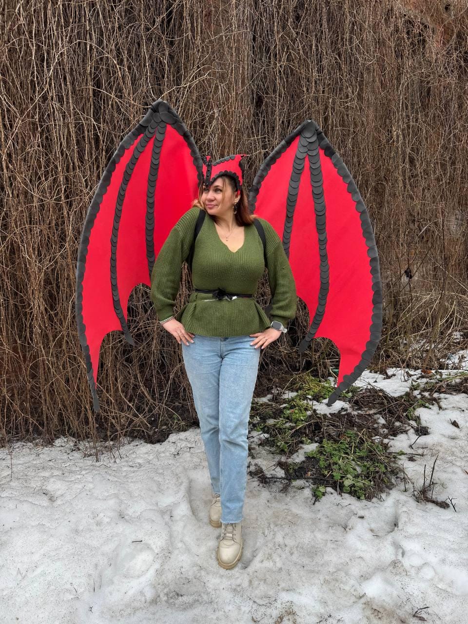 May include: Red and black dragon wings with matching headpiece. The wings are a vibrant red with black trim and a scalloped edge. The headpiece is black with red accents. The wings are large and spread out, suggesting a costume or cosplay item.