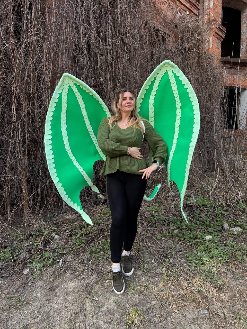 May include: Bright green dragon wings with scalloped edges. The wings are large and spread out, with a detailed vein pattern. The wings are a vibrant green color, perfect for a costume or cosplay.