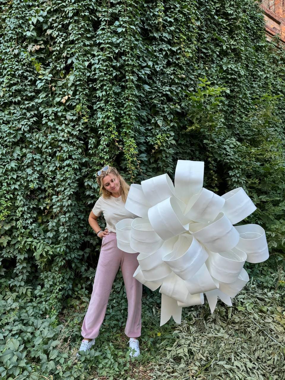 May include: A large, oversized white decorative bow constructed from wide, smooth ribbon loops arranged in a dense, spherical shape. The bow features multiple layers of overlapping, rounded loops that create a voluminous, three-dimensional appearance.
