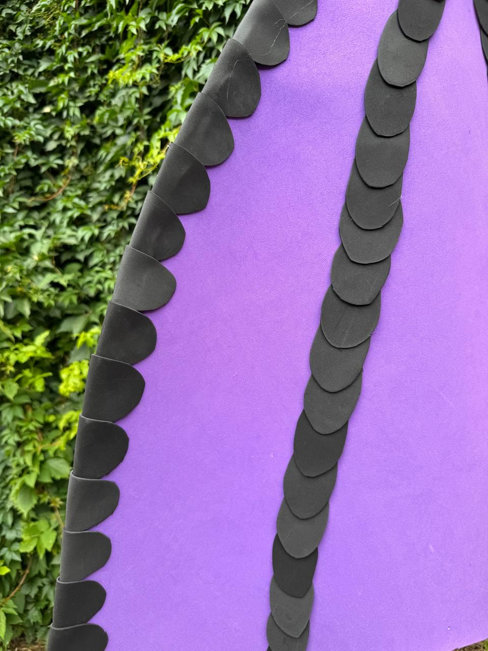 May include: A vibrant purple fabric garment featuring two vertical rows of overlapping black circular appliques. The black circular pieces are arranged in a scalloped pattern, creating a distinct textured border along the purple material.