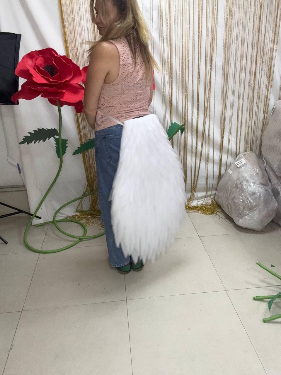 May include: A white faux fur tail accessory attached to a thin strap worn around the waist. The tail is long, thick, and features a tapered, pointed end with dense, fluffy white synthetic fibers that mimic the appearance of a large animal tail.