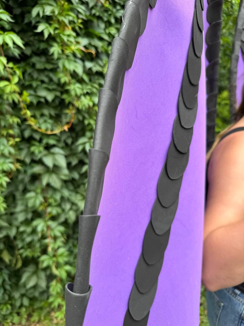 May include: A pair of large, vibrant purple wings featuring a structured black border and a vertical row of overlapping black circular accents running down the center. The wings are crafted from a smooth, matte material with a distinct, layered design.